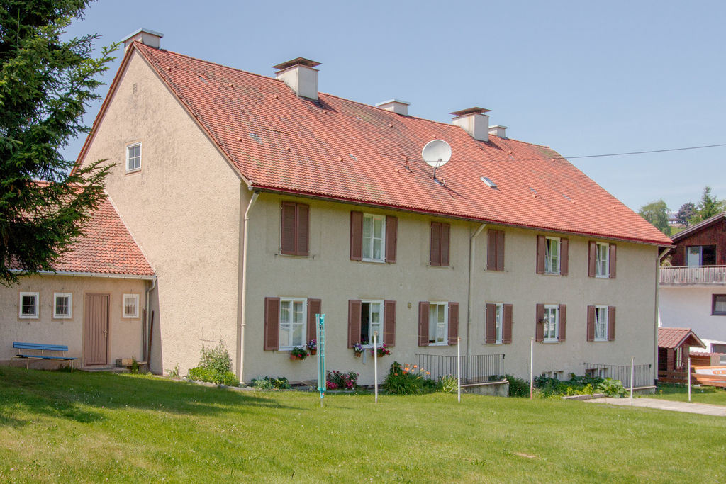 Ein Mehrfamilienhaus neben einer Wiese