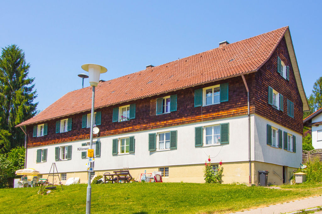 Ein Mehrfamilienhaus mit rotem Dach