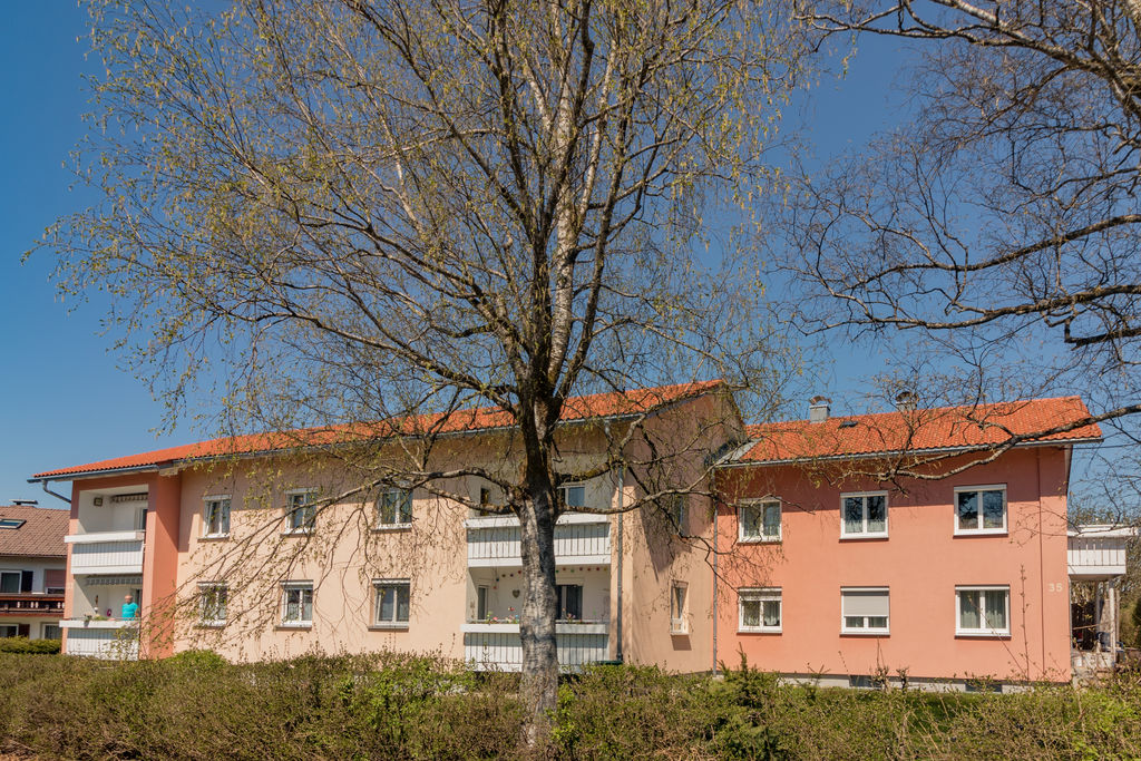 Ein Mehrfamilienhaus neben Bäumen